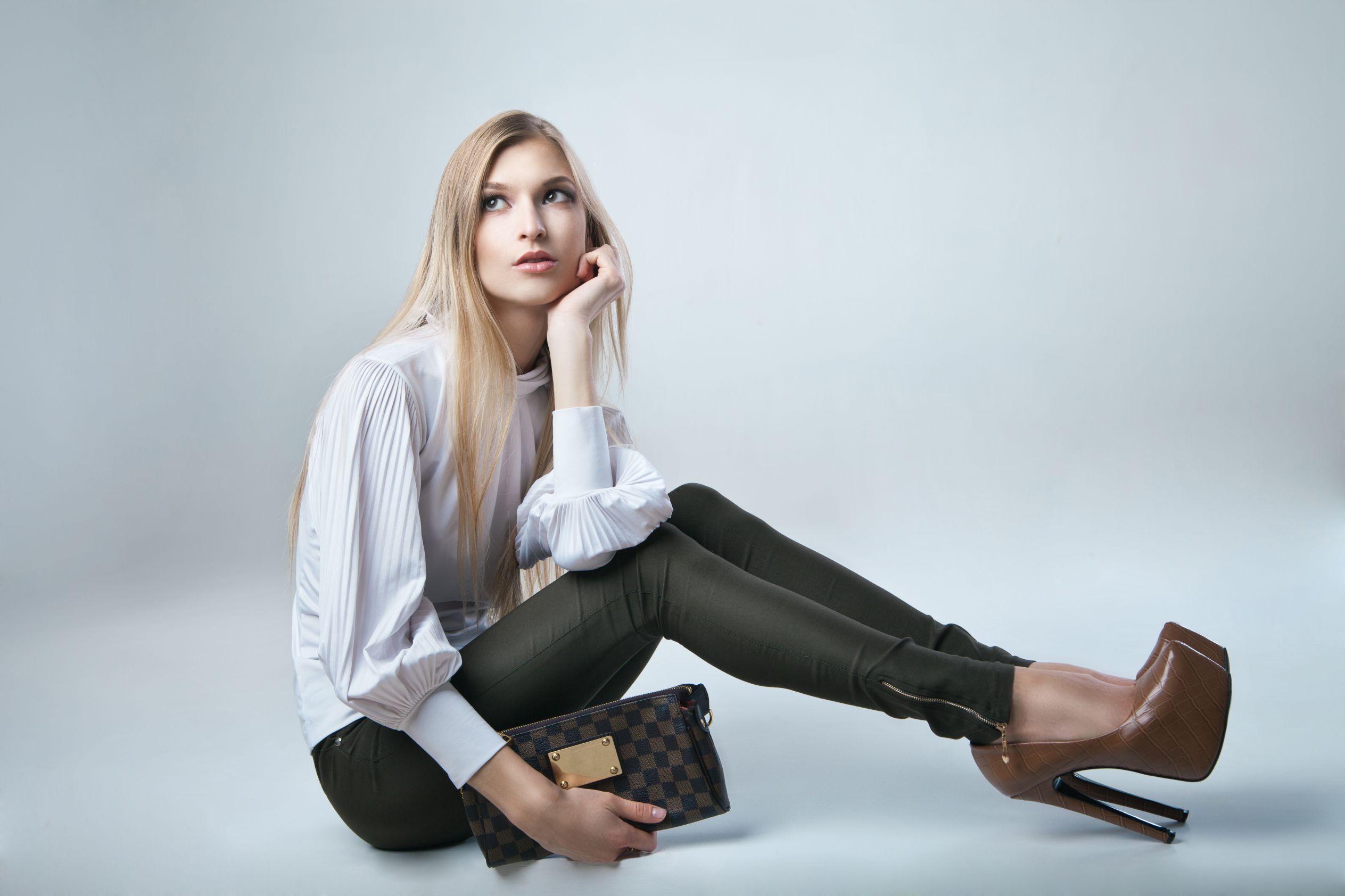 Full length casual young fashionable woman with a bag in light background